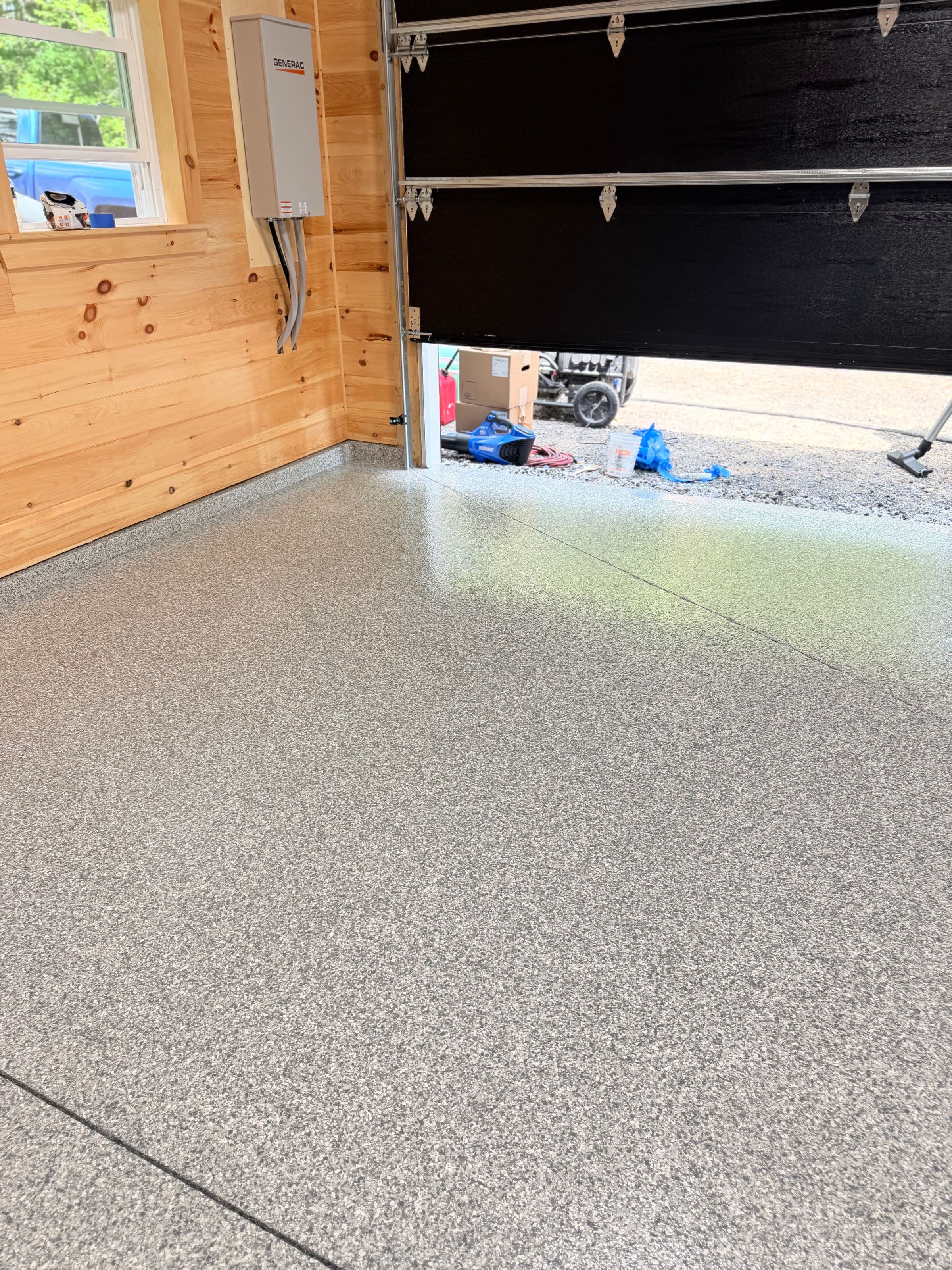 Camp garage with flake epoxy floor looking toward the entry door