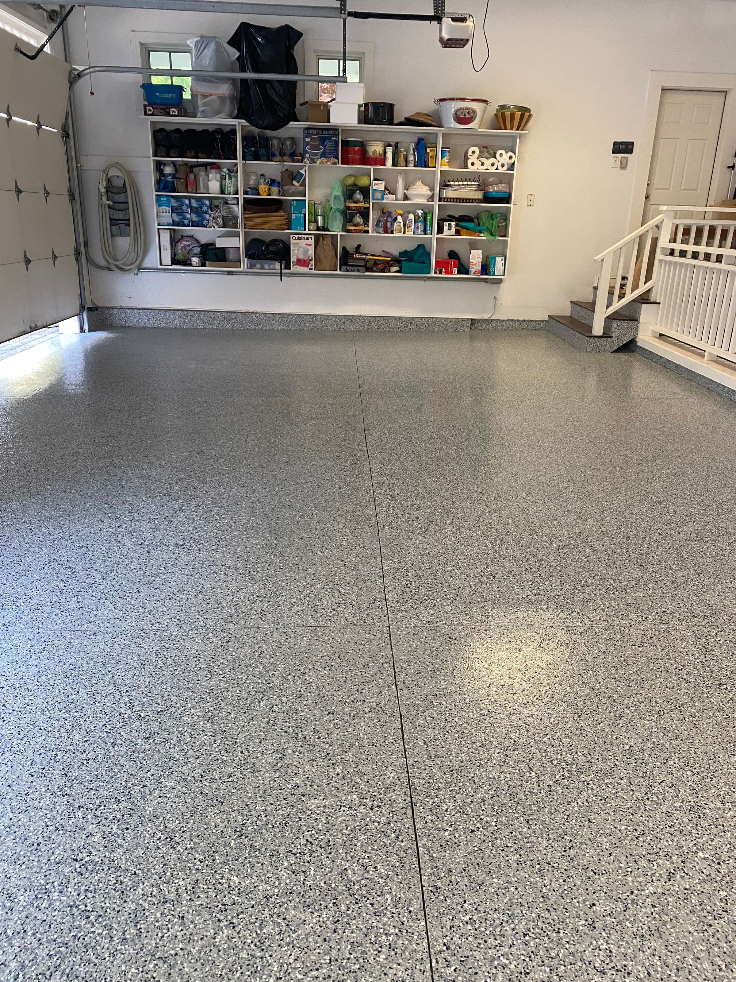 Garage with gray full-flake epoxy floor, shelving and gear along the walls