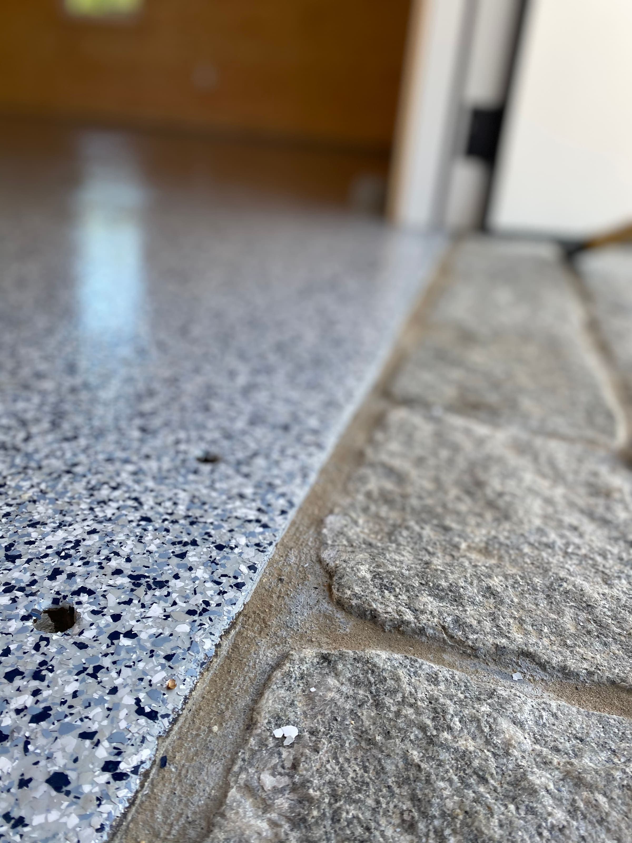 Flake epoxy floor meeting a granite ledge
